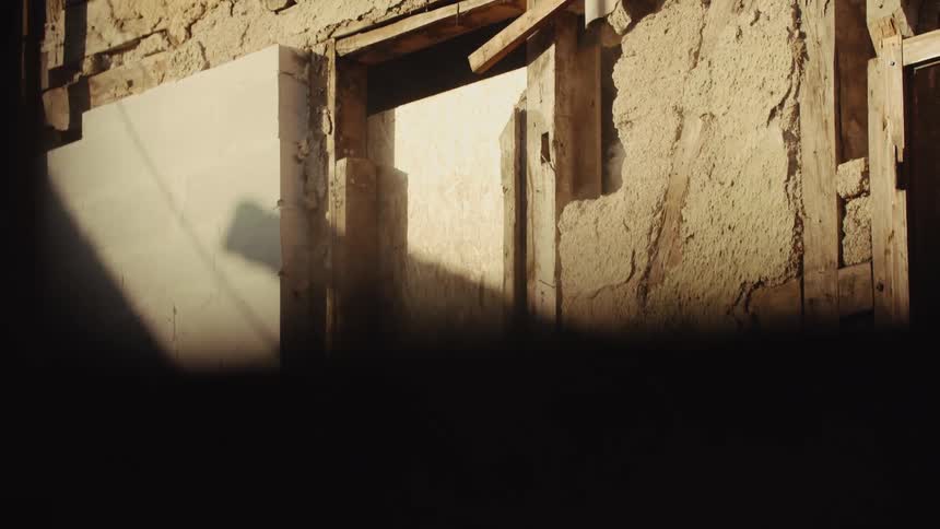 Interior wall is being demolished during a renovation with debris and dust in the air