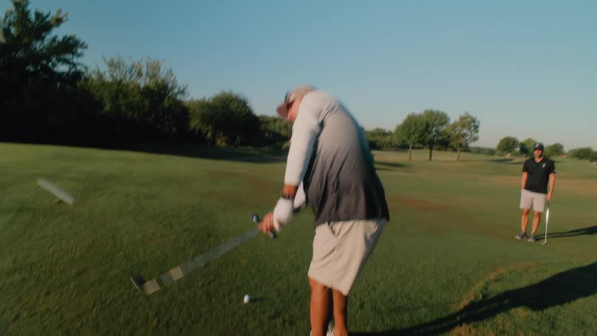 Two people golfing on a sunny day