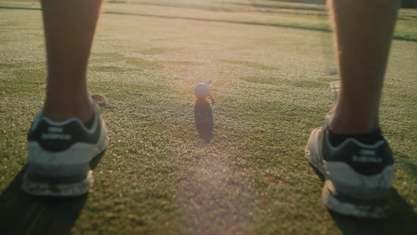 A man putting a golf ball on a green