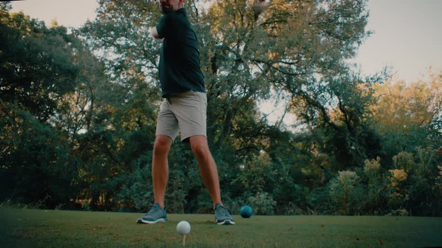 A man driving a golf ball on a course