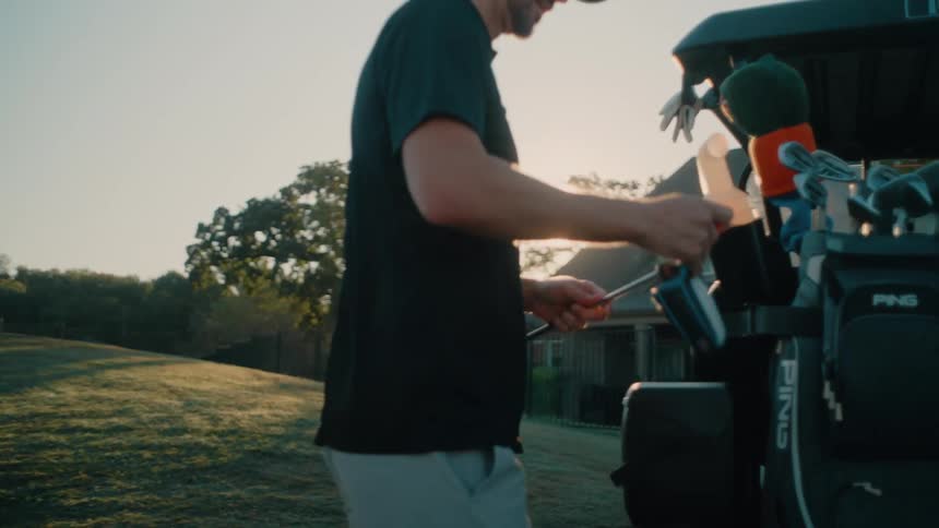 Golfer stores equipment in the cart at the end of the play