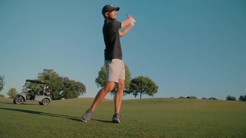 A man swinging a golf club on a golf course