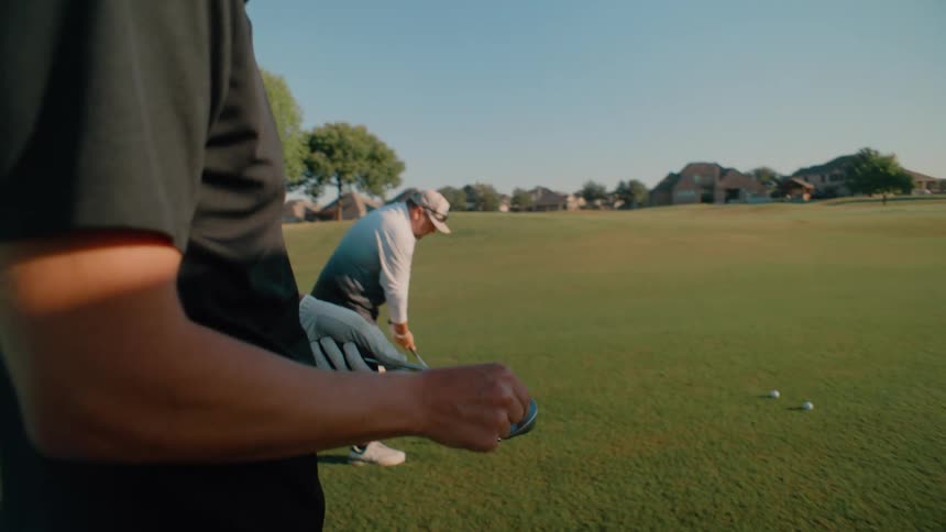 Two men golfing outdoors on a sunny day
