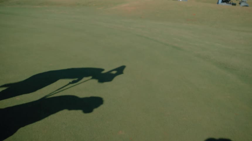 Shadow of two people on a golf course