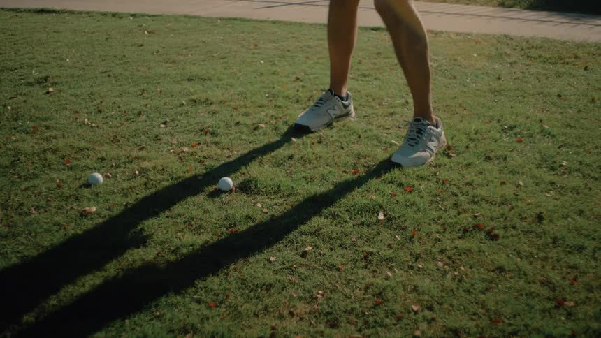 Man stands holding his golf club near the ball then swings and hits the ball