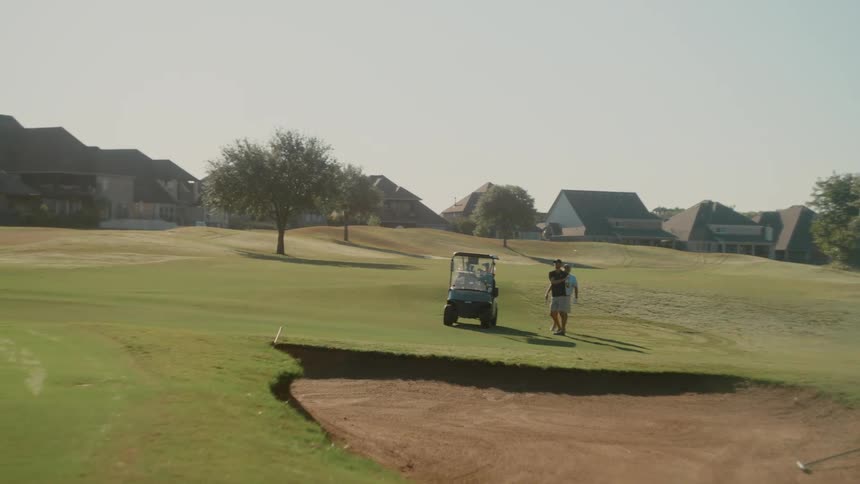 Two people playing golf on a course during the day