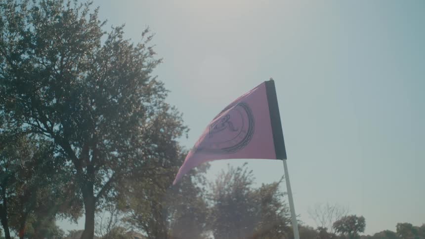 Pink flag waves in the breeze on the golf course