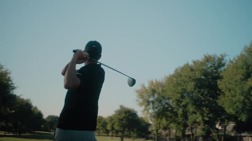 Man in a cap playing golf on an outdoor course