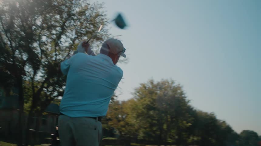 A man hitting a golf ball with a driver