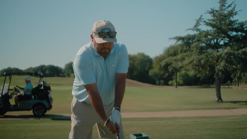 A man hitting a golf club to drive a ball