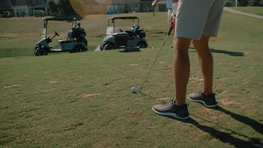 Two men getting ready to tee off on a golf course