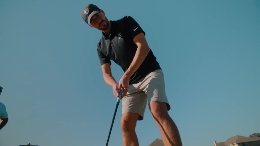 Man in cap focused on playing golf