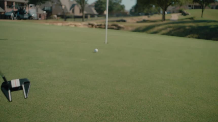Golf ball remains near the hole on the green with the flagstick at the center of the course