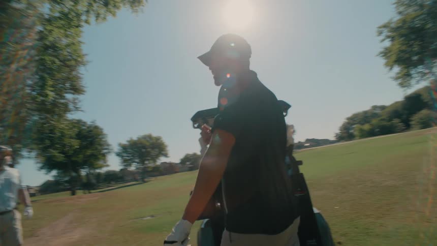 A golfer standing outdoors holding a club