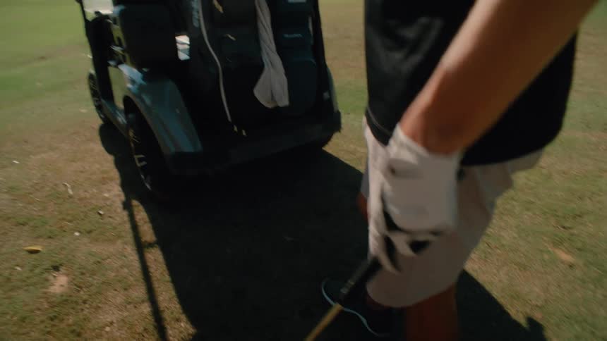 Man in a cap examining a golf club