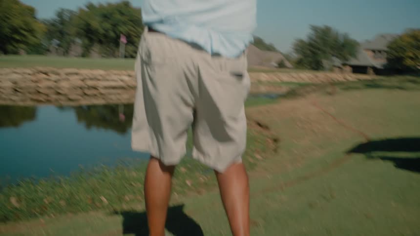 A man hitting a golf ball with a club