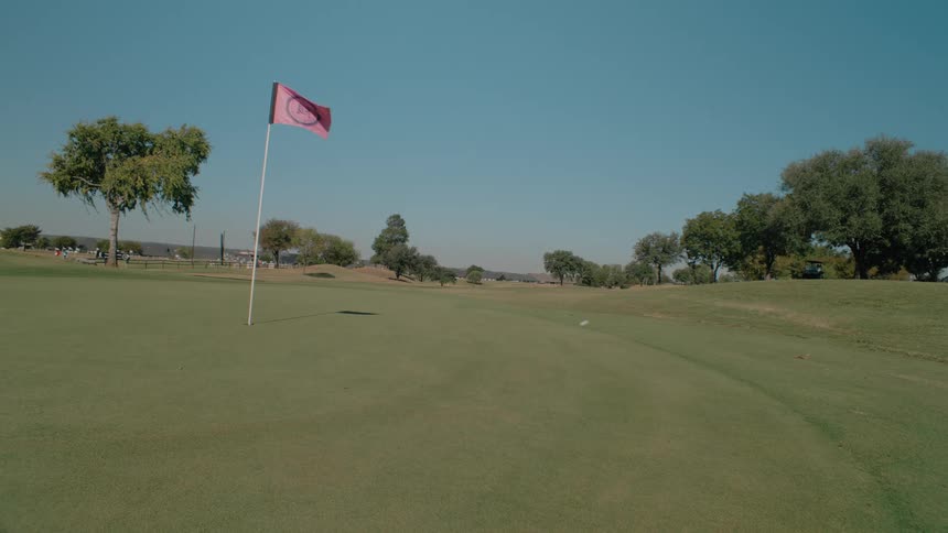 A golf ball bounces across the green
