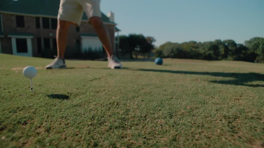 The man drives the golf ball on a sunny day