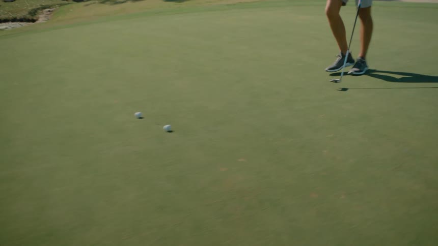 Person with a golf club taking steps backward on a grass field
