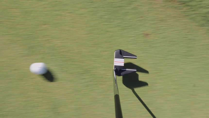 Golf club hitting a golf ball outdoors during day time