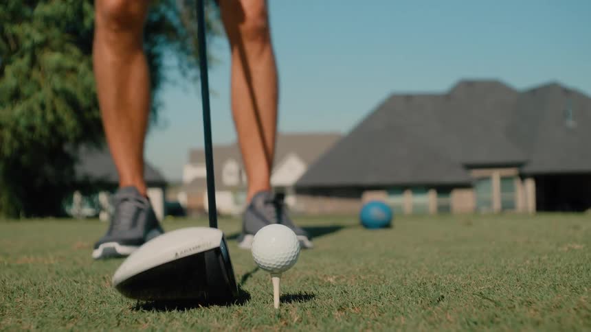 The man swings the golf club by the tee