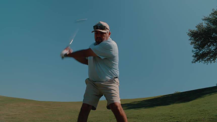 A man playing golf on a clear day