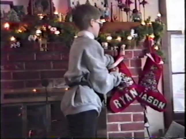 A child taking a stocking off the mantle at christmas