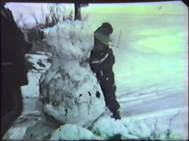 Mother and son building a snowman