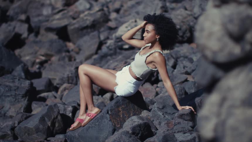 A portrait of a woman laying on some rocks