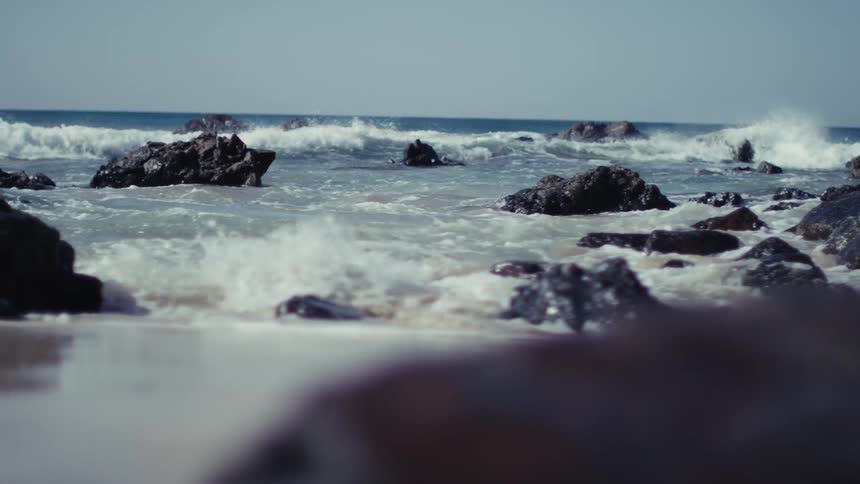 Ocean waves breaking among rocks near the shoreline