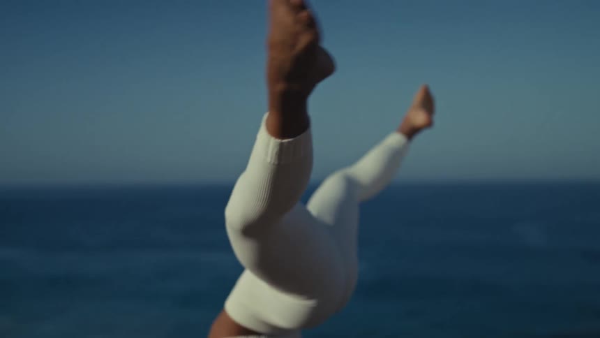 The woman is doing a handstand on her yoga mat