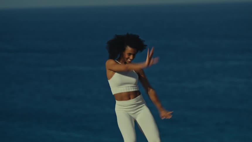The woman is dancing on the cliff