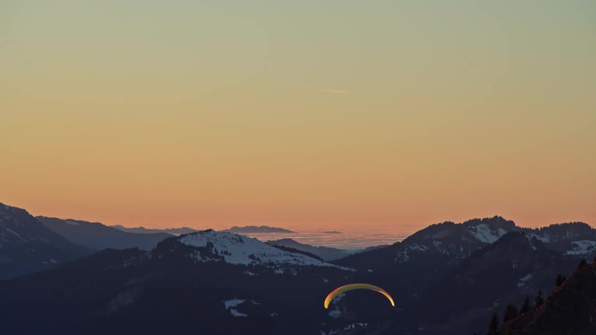 A view of a sunset over some mountains in the distance