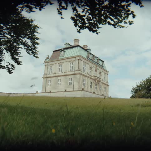 The hermitage hunting lodge sits alone on a wide expanse of open countryside surrounded by sweeping stretches of green grass