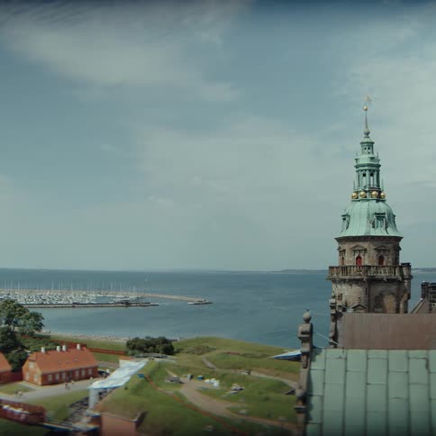 Historic tower in the foreground with coastline marina and sea in the background