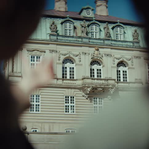 Two female tourists admiring a historical building and pointing at it while talking on a windy setting outdoors during day time