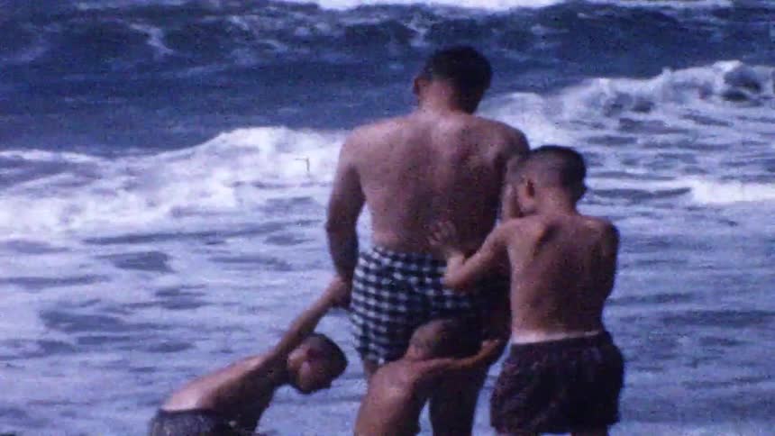 A father and kids playing at the beach