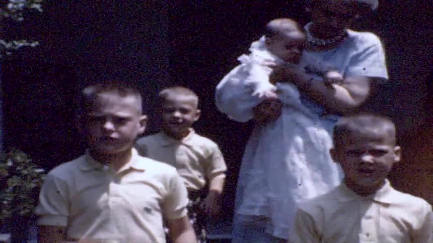 Group of children and adults gathered outdoors in an old home recording