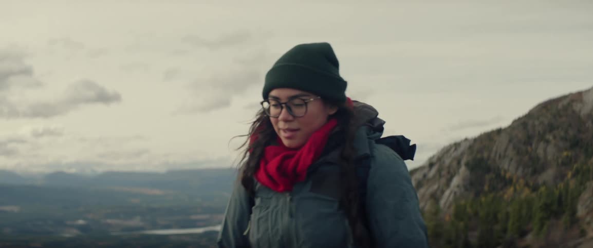 Young woman wears a backpack as she hikes in the mountains