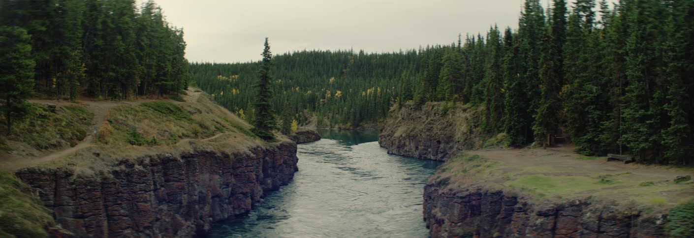 Narrow river between rocky cliffs with dense forest along the banks