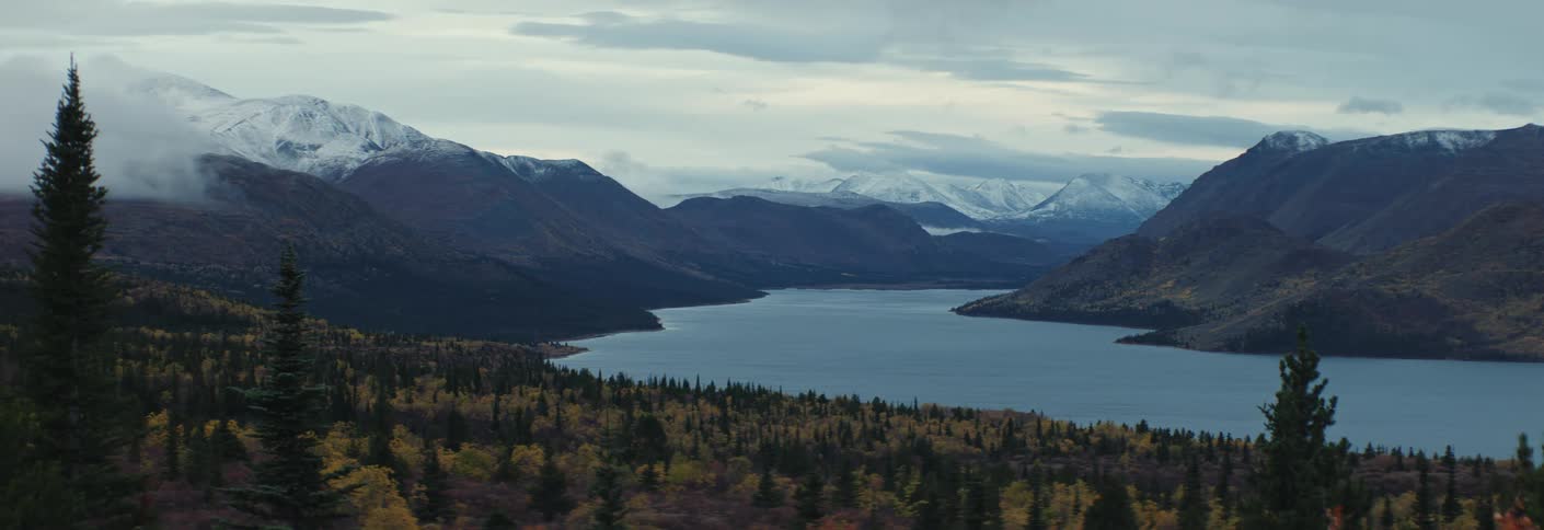Landscape view of subarctic terrain with large lake and snowy mountains