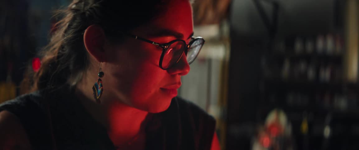 Red light from a hot furnace shines on a womans face