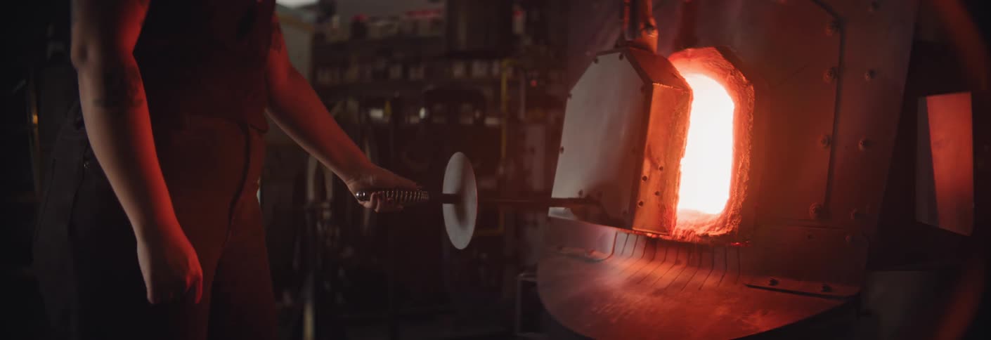 The worker opens the door of the hot forge