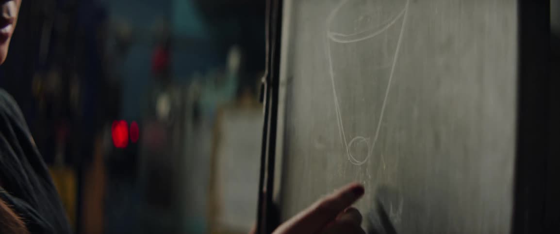 A woman sketching with chalk on a board in a workshop