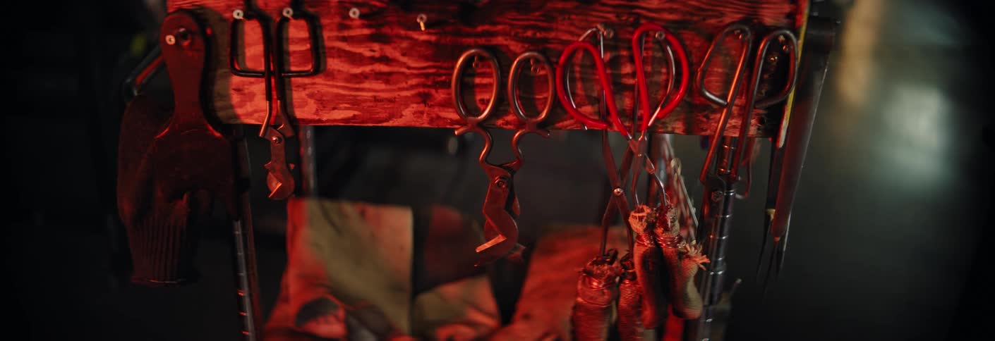 Fire illuminates some heavy-duty scissors hanging in a workshop