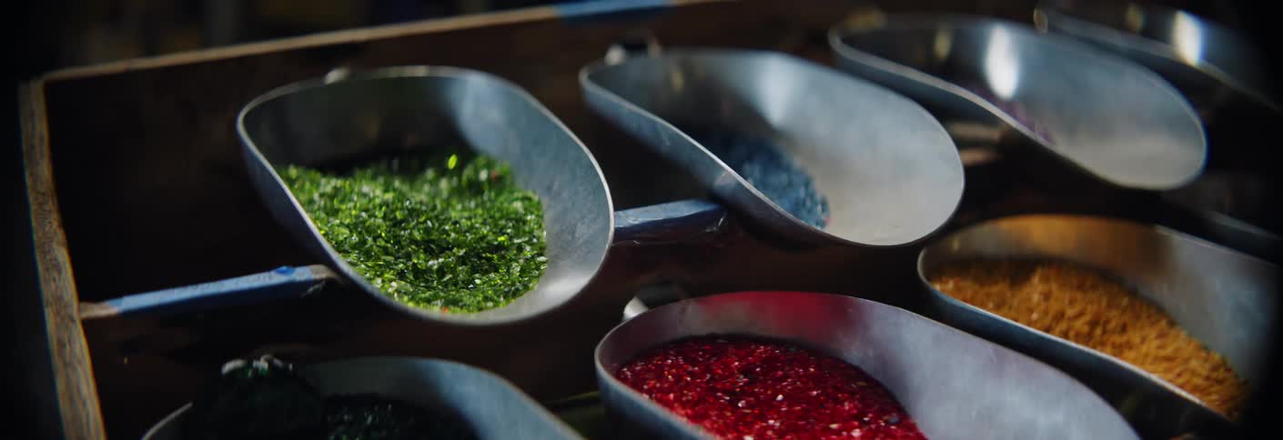 Scoops full of colorful glass grains