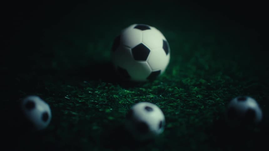 A soccer ball behind three mini soccer balls