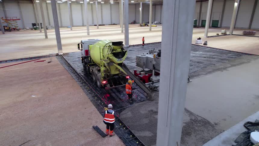 Some construction workers pouring concrete
