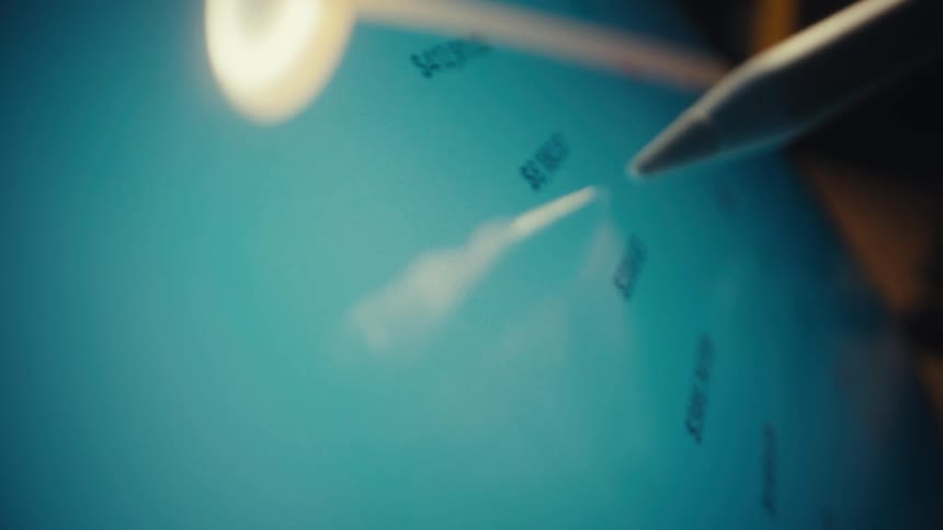 A hand uses a white stylus to scroll through a financial dashboard on a tablet displaying fluctuating stock graphs percentage changes and cryptocurrency market cap rankings against a glowing blue interface