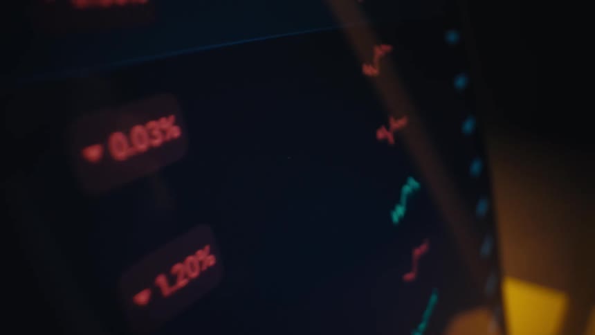 A person uses a white stylus to scroll through a cryptocurrency market dashboard on a tablet displaying live prices for bitcoin and ethereum alongside fluctuating percentage changes and red and green candlestick trend lines